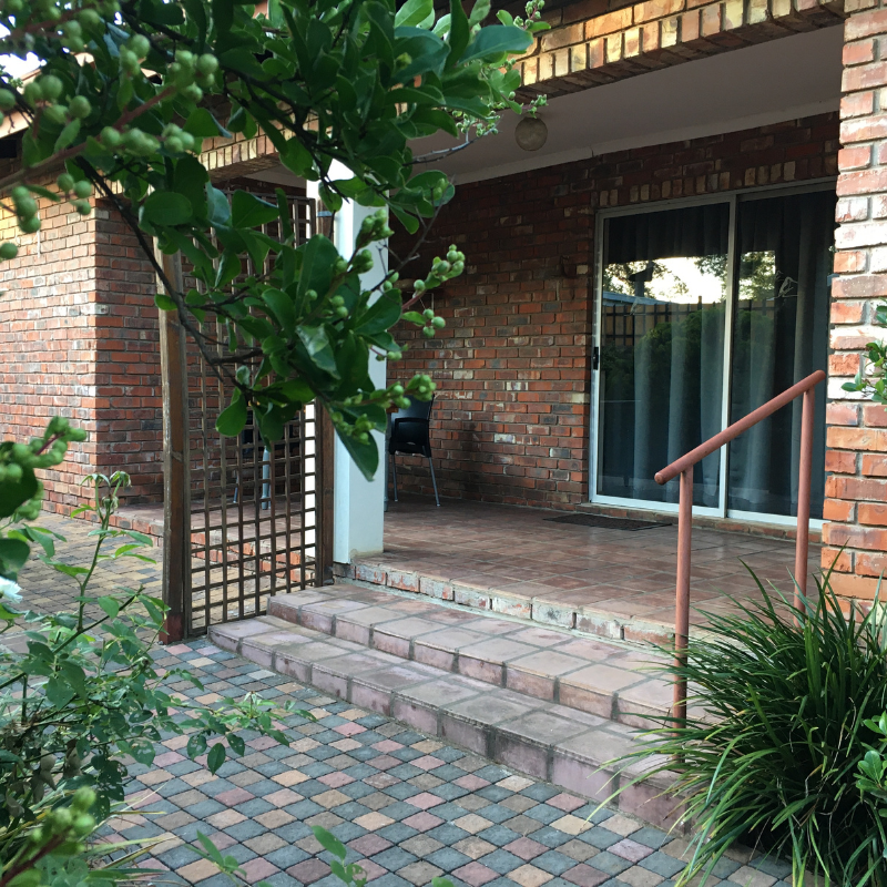 Tiled veranda entrance steps and sliding door to a guest room at Bloom Guest House in Dan Pienaar, Bloemfontein.